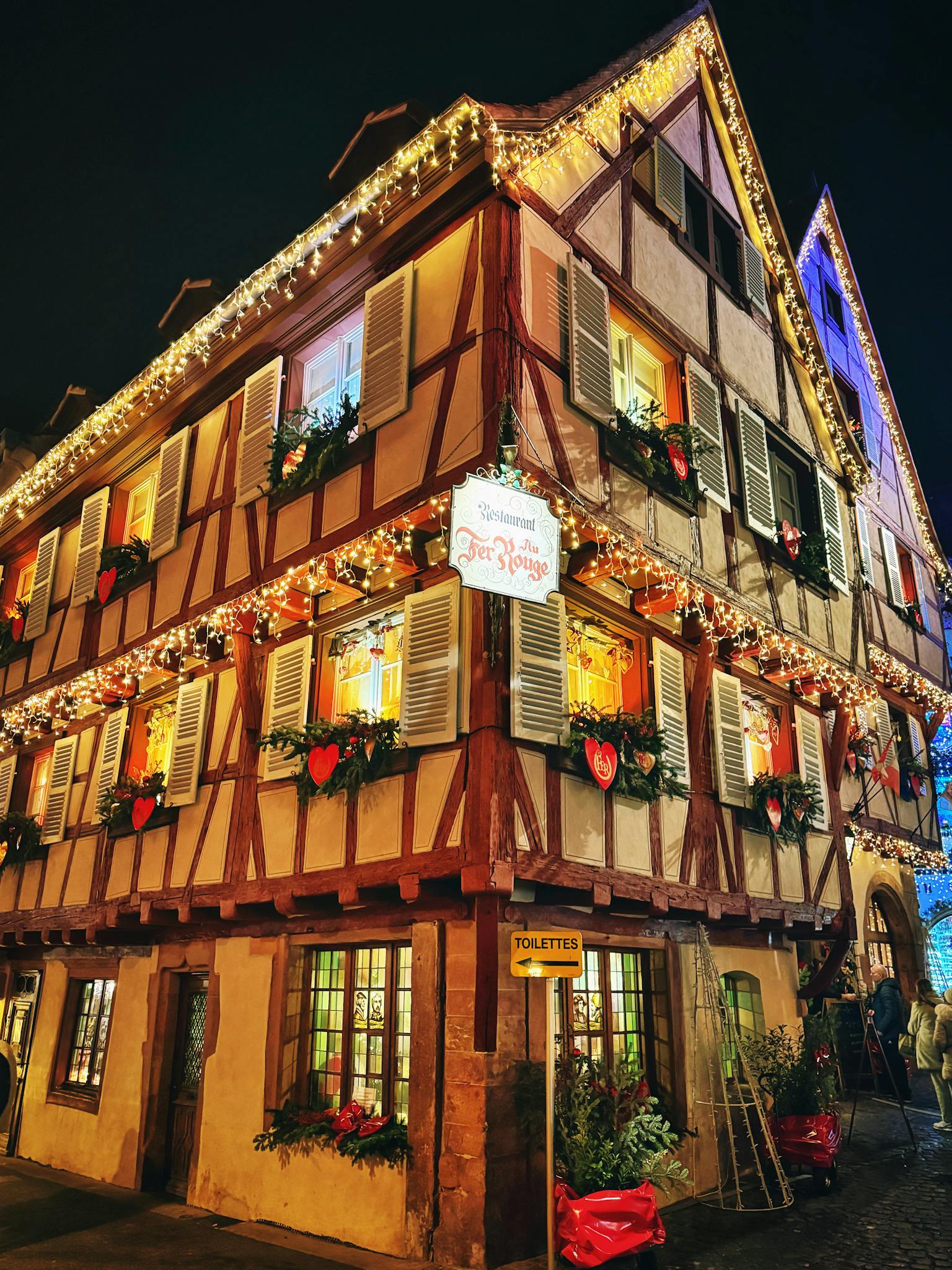 Beautifully decorated traditional European house with Christmas lights at night.