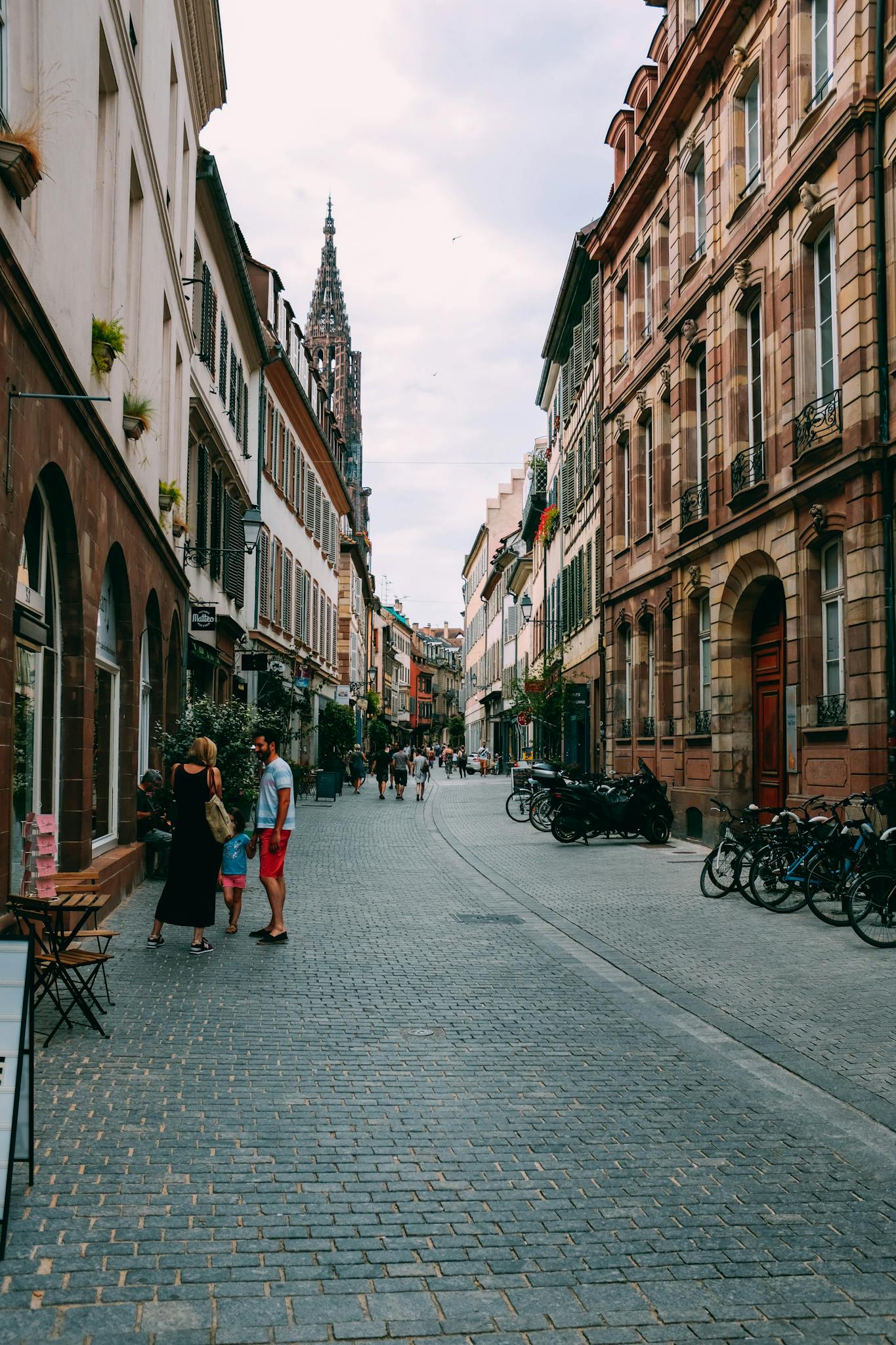 Scenic city street lined with historic buildings, bicycles, and Gothic architecture.